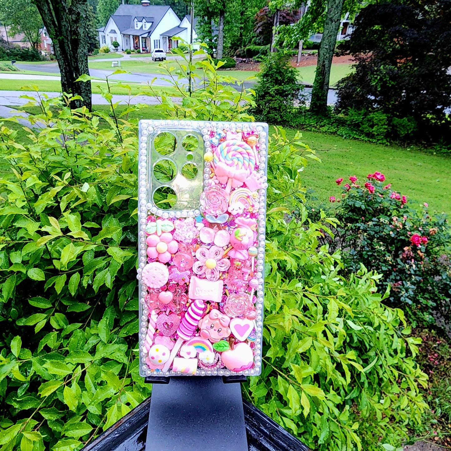 Handmade Kawaii Pink Candy Decoden Phone Case with candy-themed charms and rainbows on display.