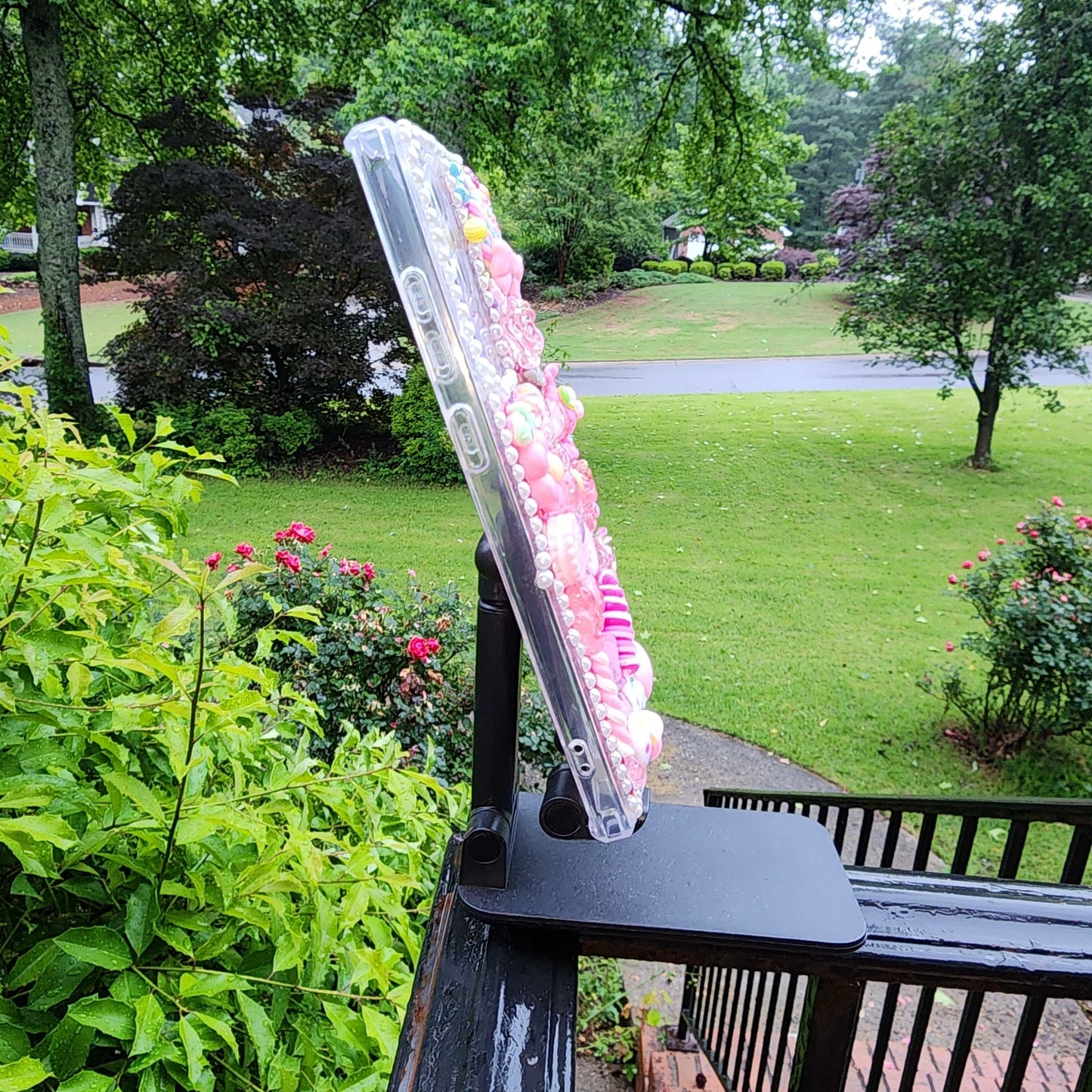 Handmade Kawaii Pink Candy Decoden Phone Case displayed on stand outdoors.